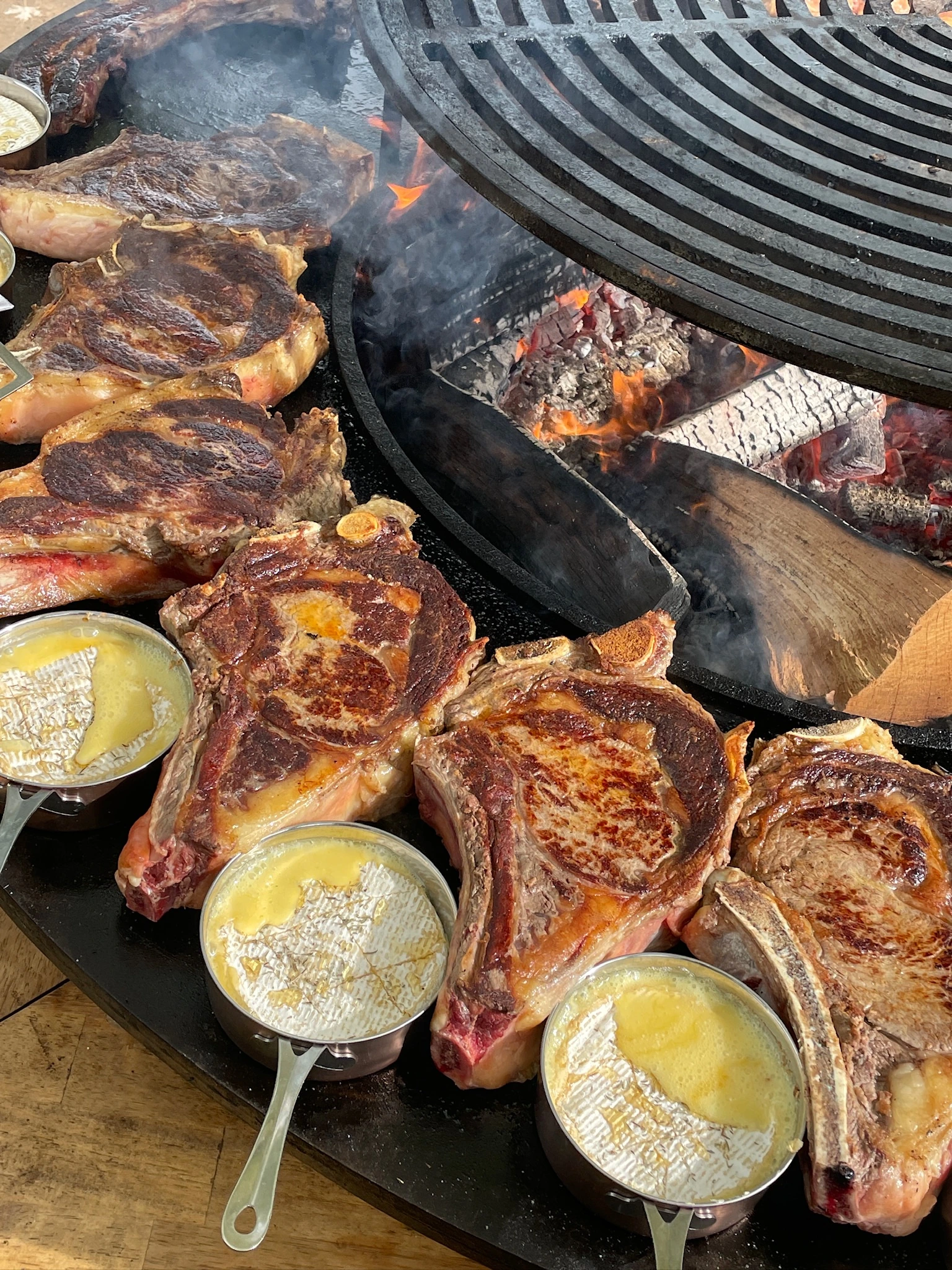 Côtes de bœuf, feu et poêlons autour du braséro